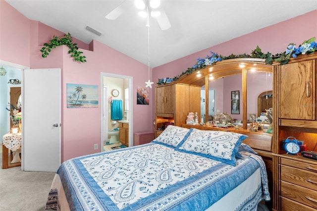 carpeted bedroom with ceiling fan, lofted ceiling, and ensuite bath