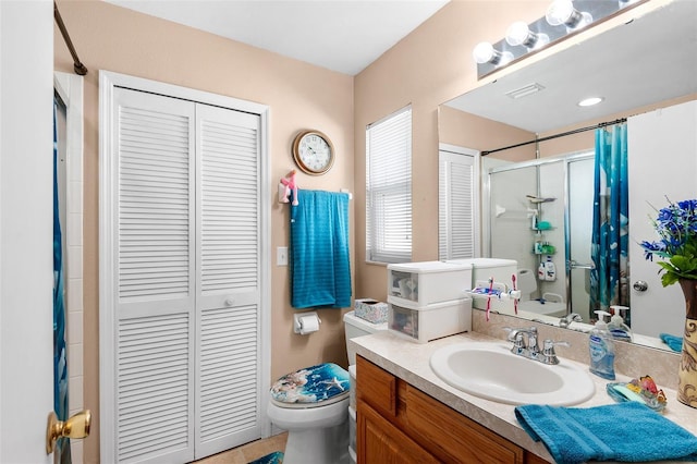 bathroom with vanity, toilet, and a shower