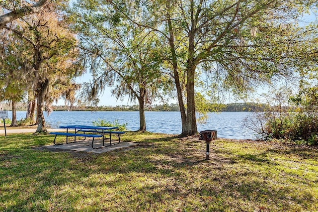 view of home's community with a water view and a yard