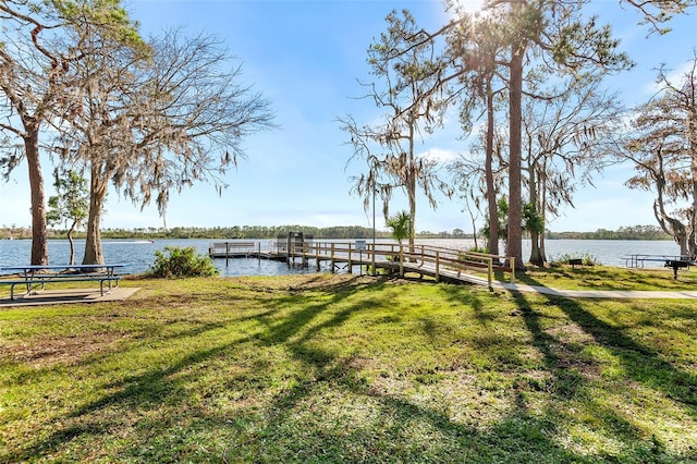 dock area featuring a lawn and a water view