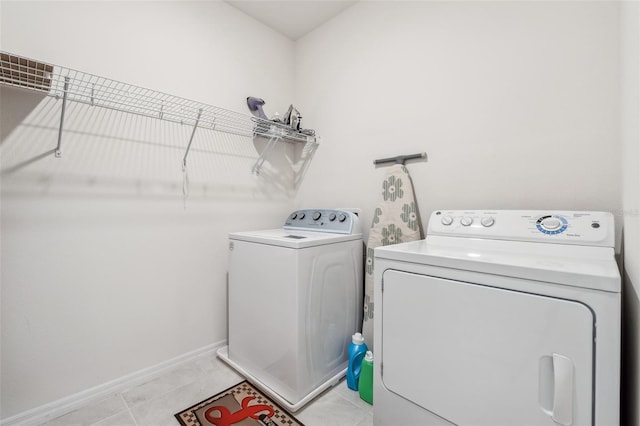 laundry room featuring separate washer and dryer and light tile patterned floors