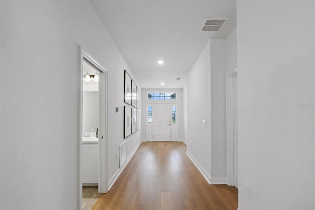 hall featuring light hardwood / wood-style floors and sink