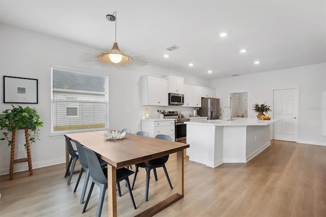 dining room with sink and light wood-type flooring