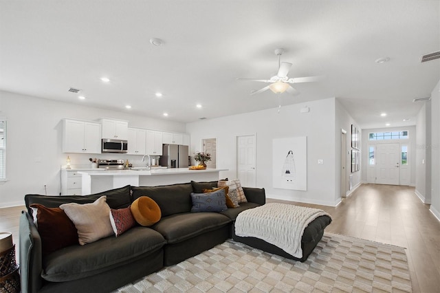 living room featuring light wood-type flooring and ceiling fan