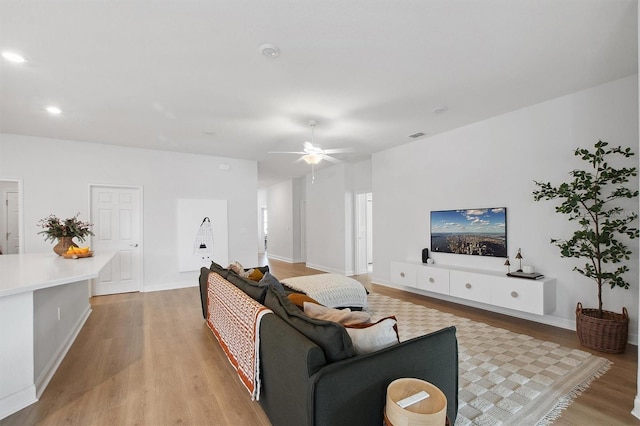 living room with ceiling fan and light wood-type flooring