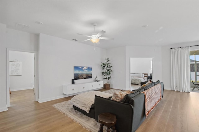 living room featuring light hardwood / wood-style floors and ceiling fan