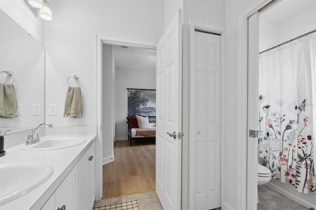 bathroom featuring toilet, wood-type flooring, and vanity