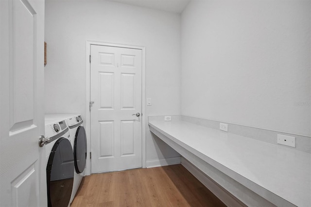 laundry area with washer and dryer and light wood-type flooring