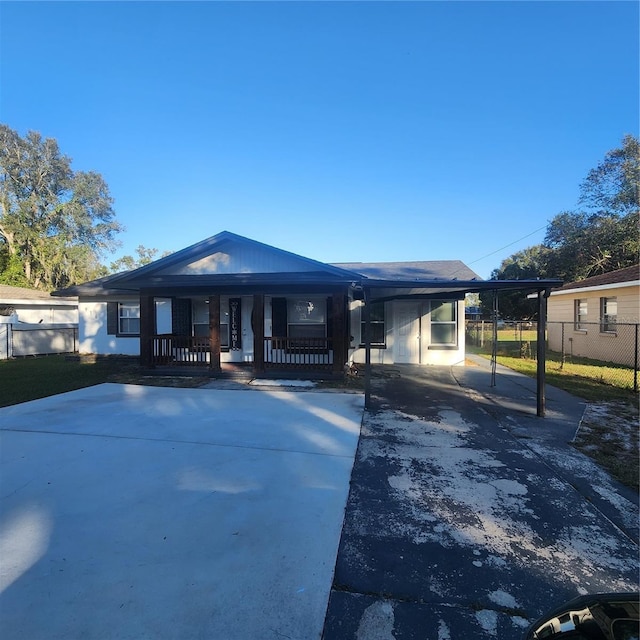 view of front of home with covered porch and a carport