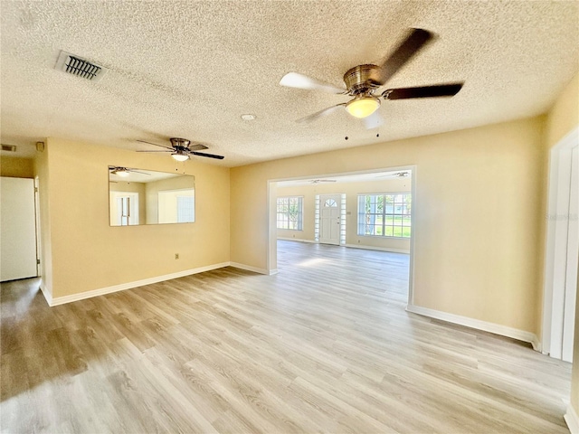 spare room with ceiling fan, light hardwood / wood-style floors, and a textured ceiling