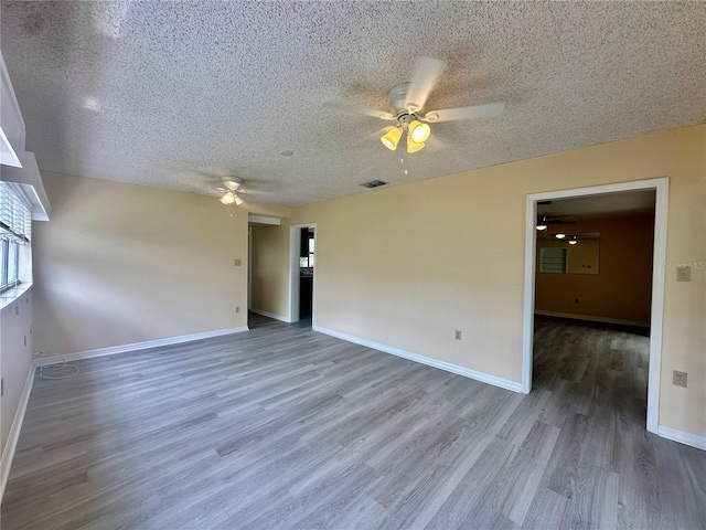 spare room with ceiling fan, a textured ceiling, and hardwood / wood-style flooring