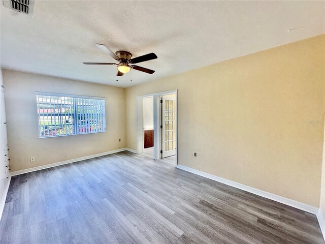 spare room featuring a textured ceiling, hardwood / wood-style flooring, and ceiling fan