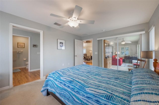 bedroom featuring ensuite bath, a closet, ceiling fan, and light colored carpet