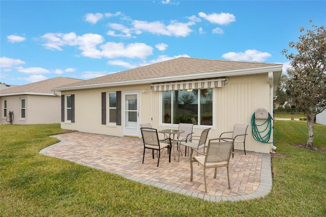 back of property with a patio area and a yard