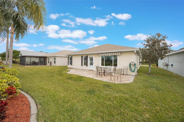 back of property featuring a yard, a sunroom, and a patio area