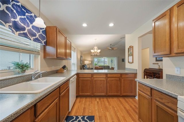 kitchen with kitchen peninsula, dishwasher, light hardwood / wood-style flooring, pendant lighting, and sink