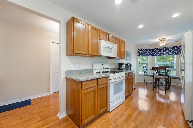 kitchen with white appliances, light wood-type flooring, and ceiling fan