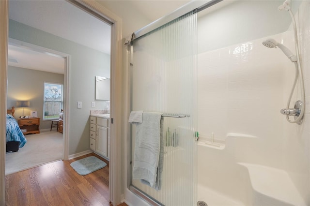 bathroom with an enclosed shower, vanity, and hardwood / wood-style flooring