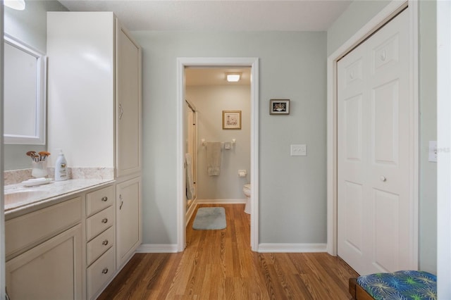 bathroom featuring hardwood / wood-style floors, an enclosed shower, vanity, and toilet