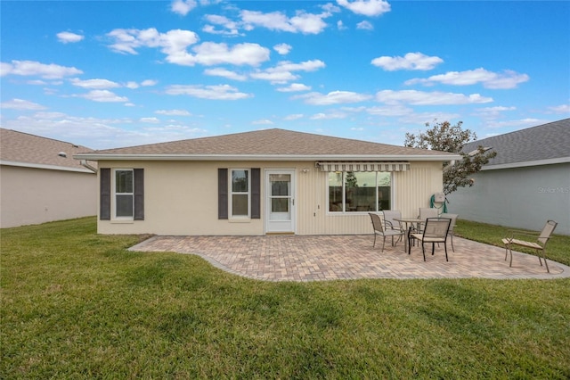 rear view of property featuring a patio area and a lawn