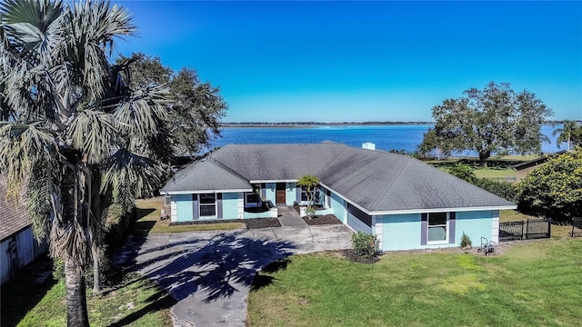 view of front of house featuring a front yard, a garage, and a water view