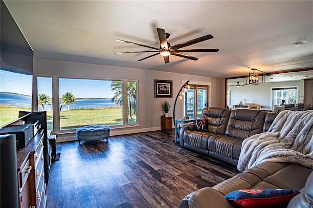 living room featuring a textured ceiling, ceiling fan with notable chandelier, a water view, and dark hardwood / wood-style floors