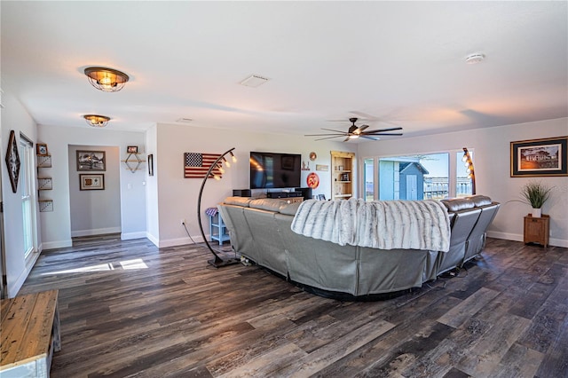 living room featuring ceiling fan and dark hardwood / wood-style floors