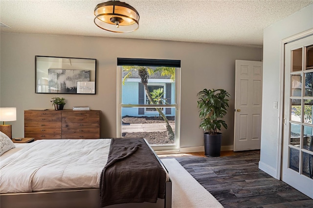 bedroom with a textured ceiling, multiple windows, and dark hardwood / wood-style floors