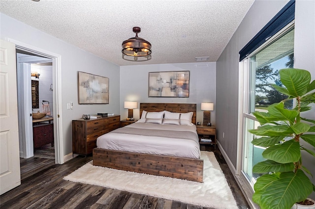 bedroom featuring a textured ceiling and dark hardwood / wood-style floors