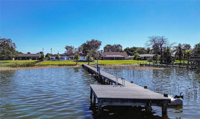 dock area featuring a water view and a lawn