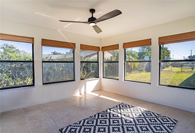 unfurnished sunroom featuring ceiling fan