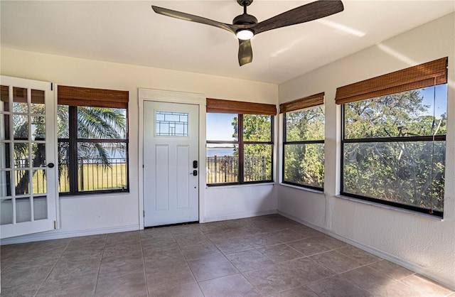 unfurnished sunroom with ceiling fan