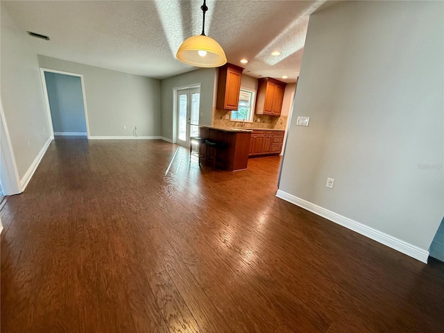 interior space with dark hardwood / wood-style floors, a textured ceiling, and french doors