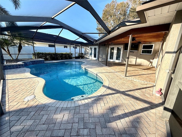 view of swimming pool with french doors, ceiling fan, glass enclosure, and a patio area