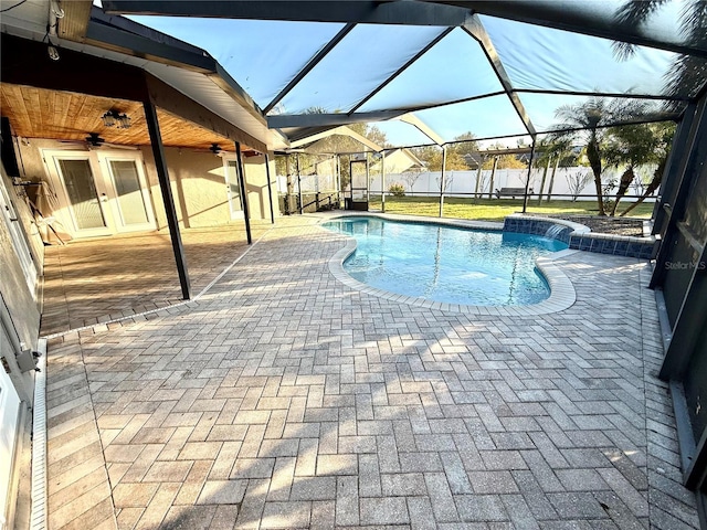 view of swimming pool with a patio, ceiling fan, and glass enclosure