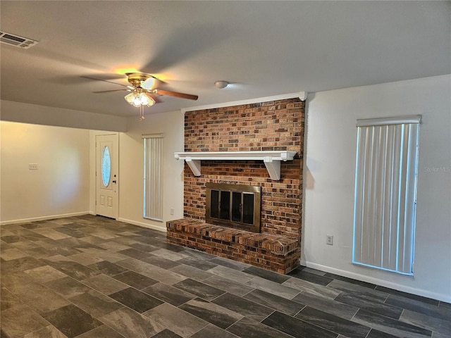 unfurnished living room with ceiling fan and a brick fireplace