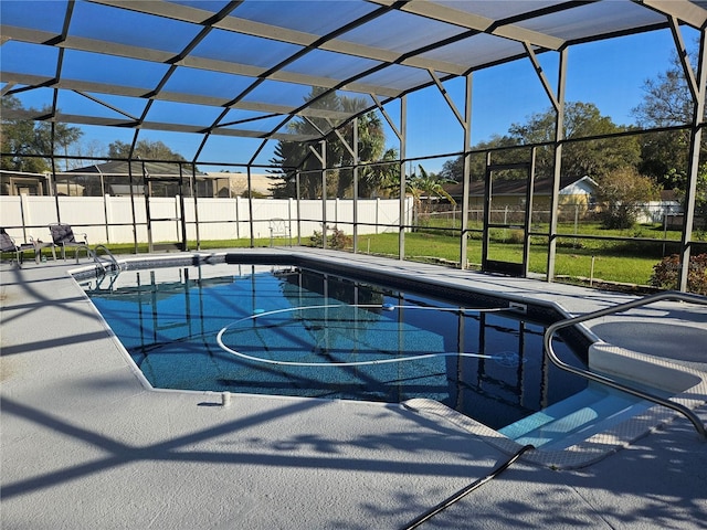 view of swimming pool featuring a lawn, glass enclosure, and a patio area