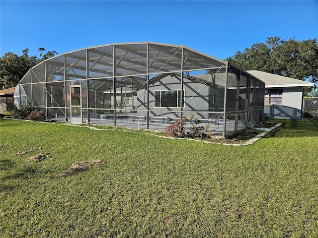 back of house featuring a pool, a lanai, and a lawn