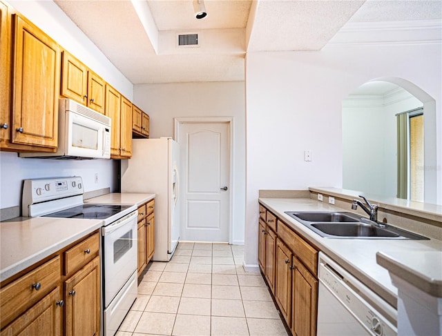 kitchen featuring light tile patterned floors, white appliances, a textured ceiling, crown molding, and sink