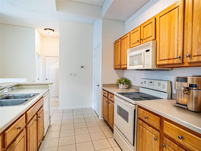 kitchen featuring sink, light tile patterned flooring, and white appliances