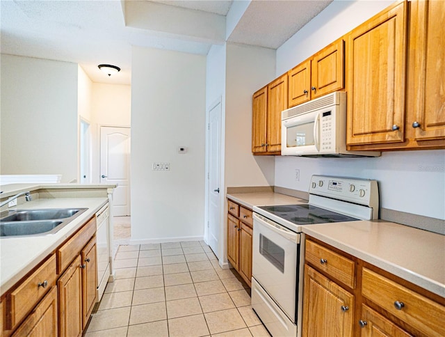 kitchen featuring light tile patterned floors, sink, and white appliances