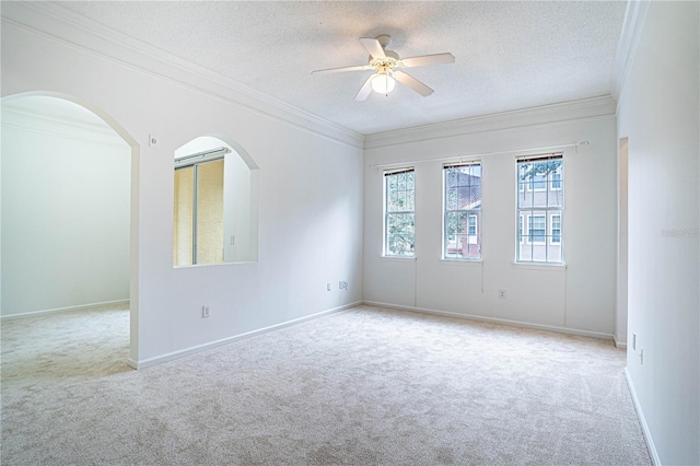 unfurnished room featuring ceiling fan, a textured ceiling, crown molding, and light carpet