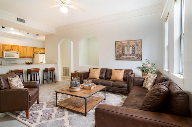 living room featuring ceiling fan and crown molding