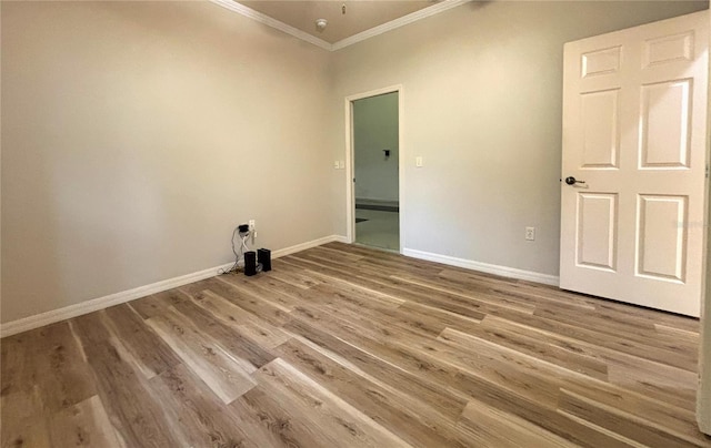 empty room with ornamental molding and hardwood / wood-style flooring