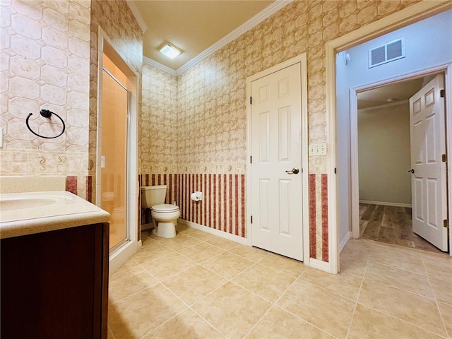 bathroom with toilet, a shower with door, tile patterned floors, ornamental molding, and vanity