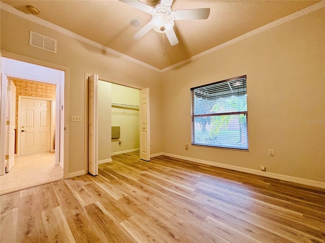 unfurnished bedroom featuring a textured ceiling, wood-type flooring, a closet, ornamental molding, and ceiling fan