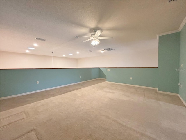 carpeted spare room featuring ceiling fan and crown molding