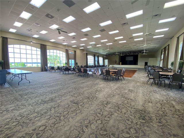 interior space featuring ceiling fan and a drop ceiling