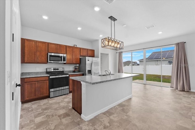 kitchen featuring pendant lighting, stainless steel appliances, a center island with sink, and sink