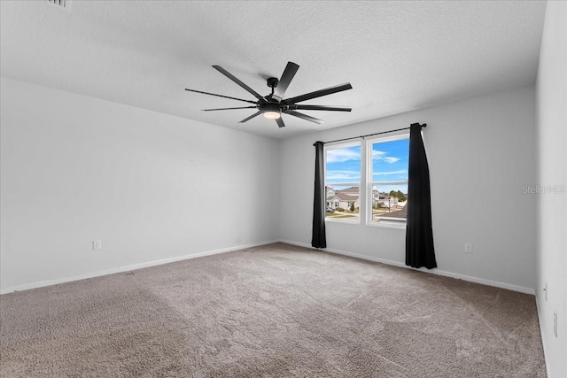 carpeted spare room with a textured ceiling and ceiling fan